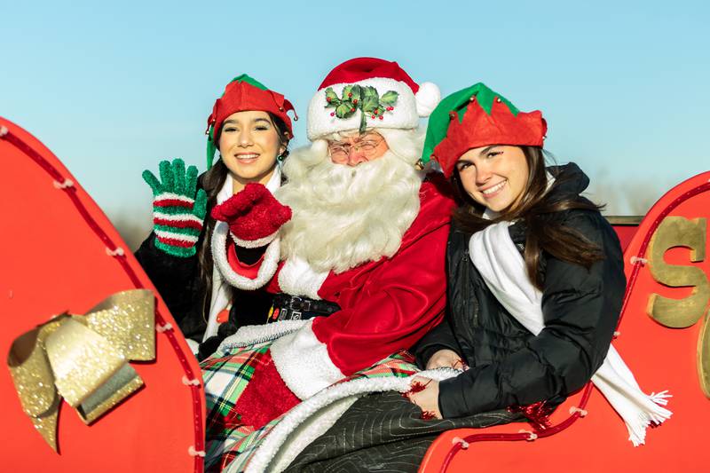 Santa and his elves (Crest Hill residents Pilar Gonzales and Kate Richardson) wave as they kick-off Crest Hill's Santa Parade on Nov. 30, 2024.