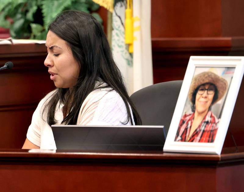 Lorena Flores, daughter of Graciela Reza Contreras, who is in the framed photo, reads a victims impact statement during the sentencing hearing for former police officer James Corralejo Thursday, July 17, 2025, at the DeKalb County Courthouse in Sycamore. Corralejo was sentenced to four years in prison for a Class 2 felony count of driving under the influence of alcohol causing death for a 2023 crash that killed Reza Contreras.