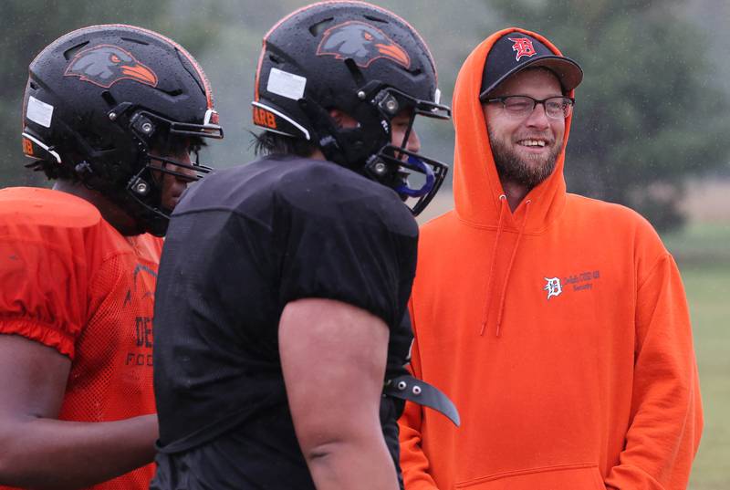 Matt Quinto, U.S. Navy veteran and DeKalb High School football coach, manages a smile despite the rain during practice Tuesday, Sept. 24, 2024, at DeKalb High School.