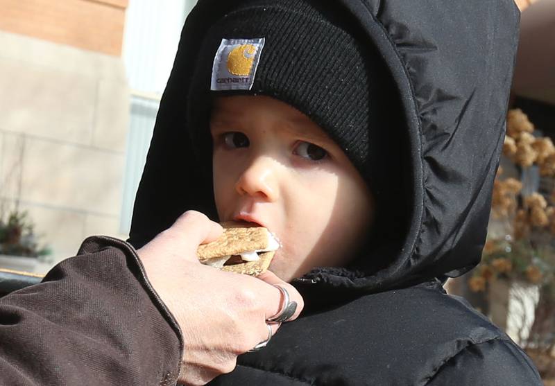 Theo Kemp of La Salle takes a bite of a S'more during the annual Miracle on First Street event on Saturday, Dec. 7, 2024 downtown La Salle. La Salle firefighters offer the S'mores and fire truck rides for children and families. Miracle on First Street began in 2009 and has continued to become a holiday tradition for families.