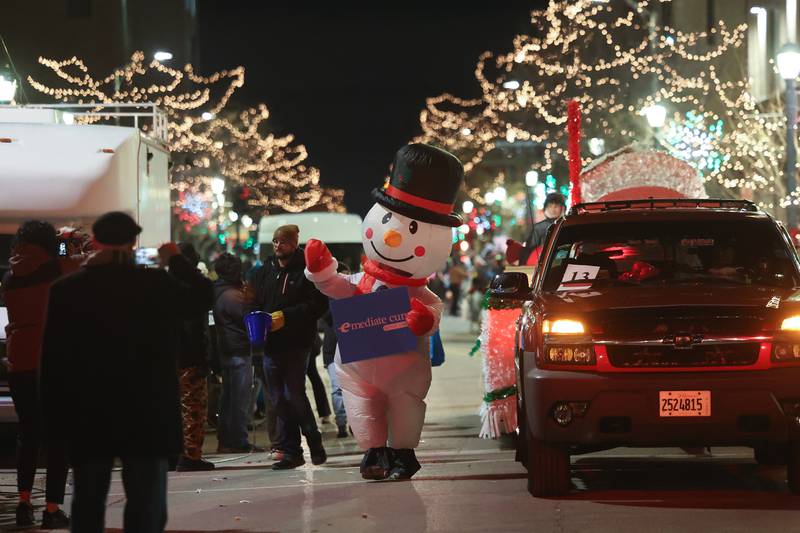 A snowman waves to the crowds at the Joliet Light up the Holidays Parade in downtown Joliet on Friday, Nov. 24, 2023.