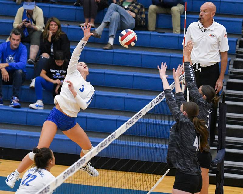 St. Charles North's Amber Czerniak, left, spikes the ball past St. Francis defenders Grace Grover (40) and Emma Delaney during the game on Wednesday Oct. 2, 2024, held at St. Francis High School in Wheaton.
