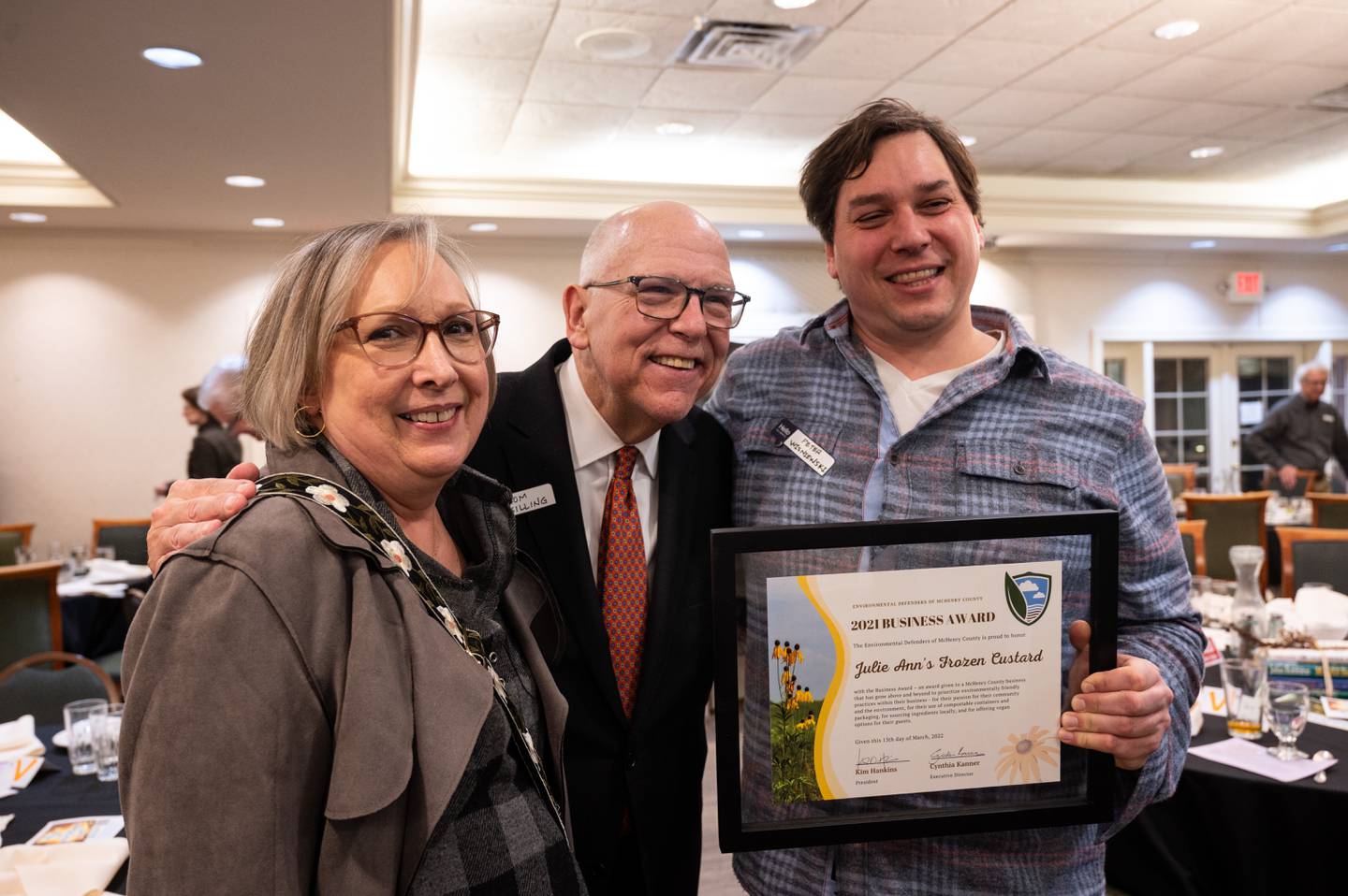 The winners of the Environmental Defenders of McHenry County's Business Award, Linda Anderson and Peter Wisniewski from Julie Ann’s Frozen Custard, pose with Tom Skilling on Sunday March 13, 2022, at the McHenry Country Club.