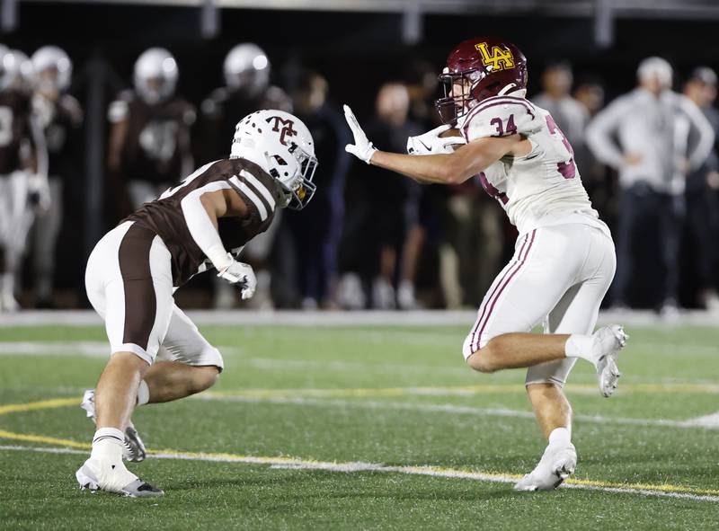 Loyola's Drew MacPherson (34) looks to get past the Mt. Carmel defense during the varsity football game between Loyola Academy and Mt. Carmel high school on Friday, Oct. 25, 2024 in Chicago.