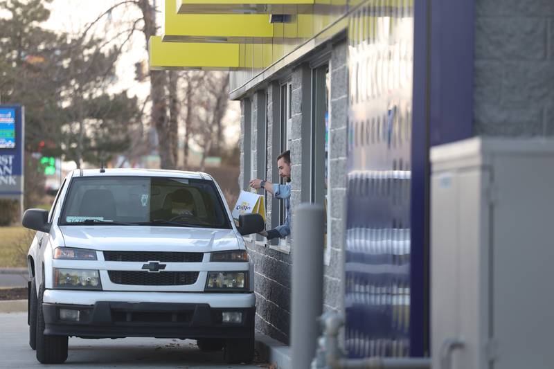 An employee hands an order to a customer at CosMc’s, McDonald’s first small format beverage driven concept drive-thru, on Friday, Dec. 8, 2023, in Bolingbrook.