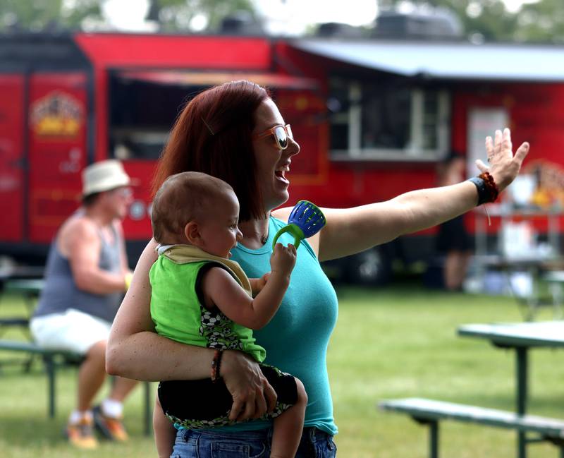 Kelly Hirsch of McHenry dances with her son Hollis, 11 months, during the final day of Bands, Brews, and BBQ at McHenry’s Petersen Park Sunday.