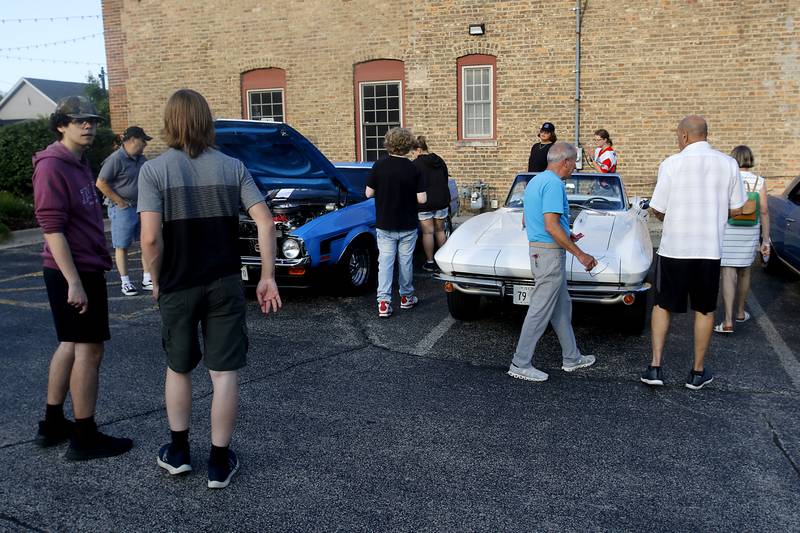 People check out muscle cars on Wednesday July 10, 2024, during the Cary Cruise Night. The weekly car show hosted by the Cary-Grove Area Chamber of Commerce draws about 125 cars and trucks each week. The event runs weekly on Wednesday through the end of August.