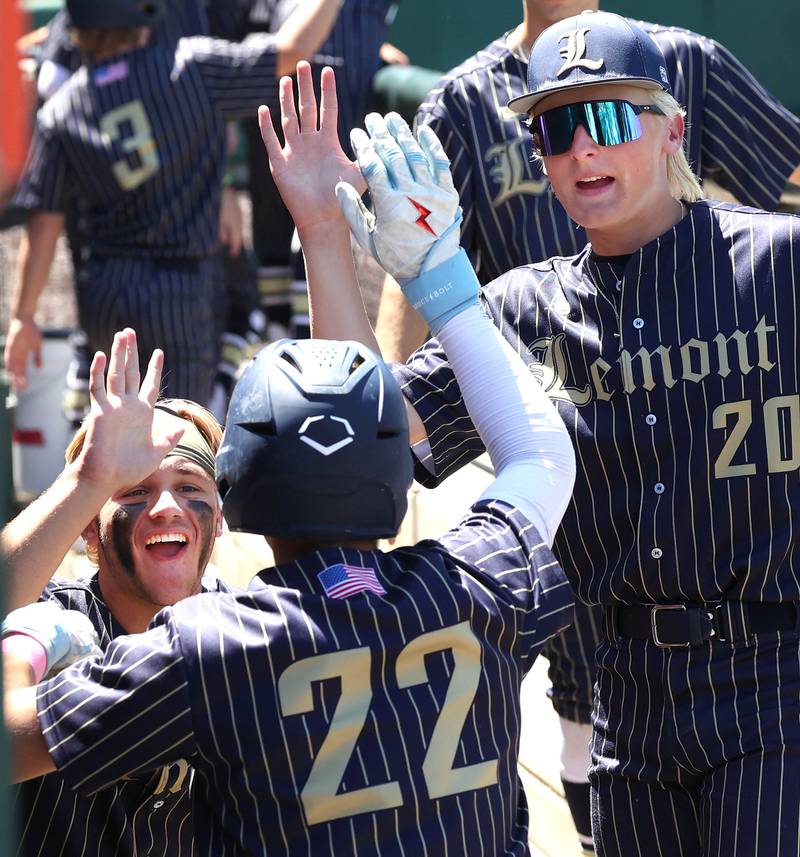 Lemont players congratulate Lemont's Matt Devoy (center) after he advanced the base runners during their Class 3A state semifinal game against Highland Friday, June 7, 2024, at Duly Health and Care Field in Joliet.