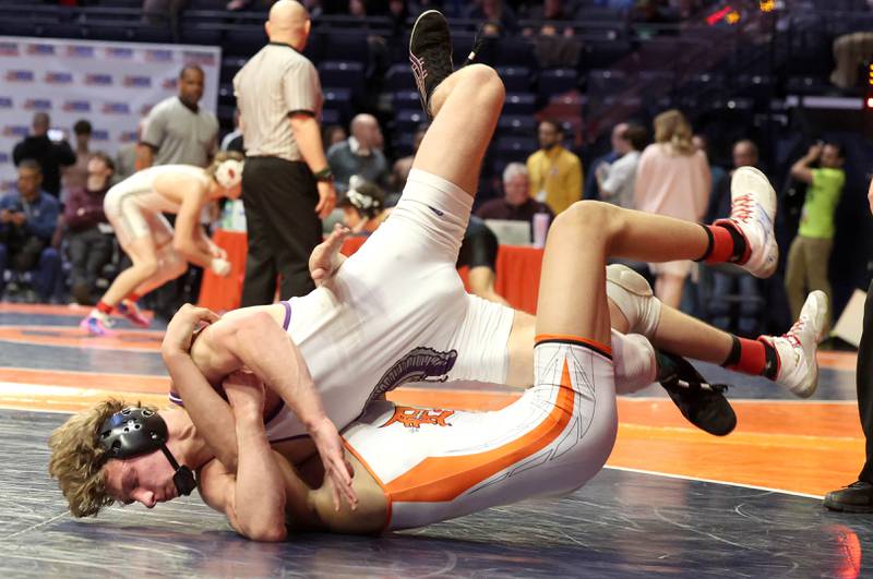Downers Grove North’s Harrison Konder takes down DeKalb’s Jacob Luce during the Class 3A 145 pound 5th place match in the IHSA individual state wrestling finals in the State Farm Center at the University of Illinois in Champaign.
