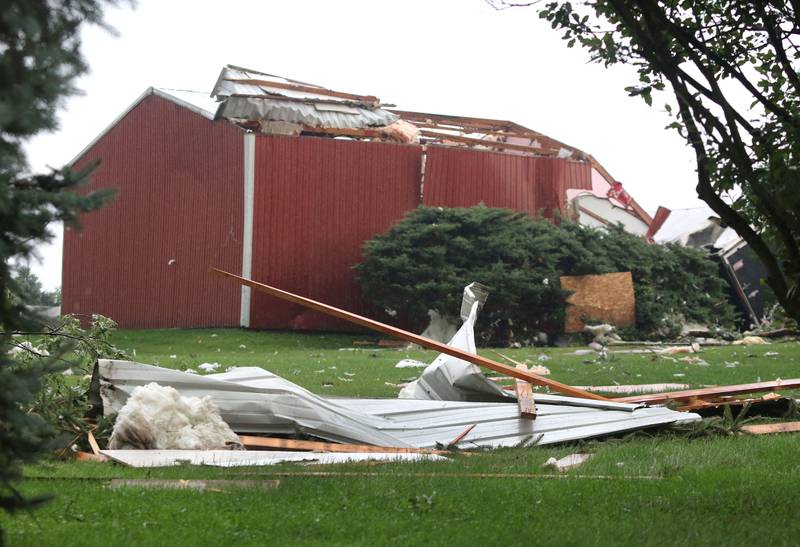 Debris litters the yard in front of a badly damaged barn at a home on Fenstermaker Road in Sycamore Monday Aug. 9, 2021, after severe weather rolled through the area. Several funnel clouds and tornadoes were reported in DeKalb County Monday afternoon.