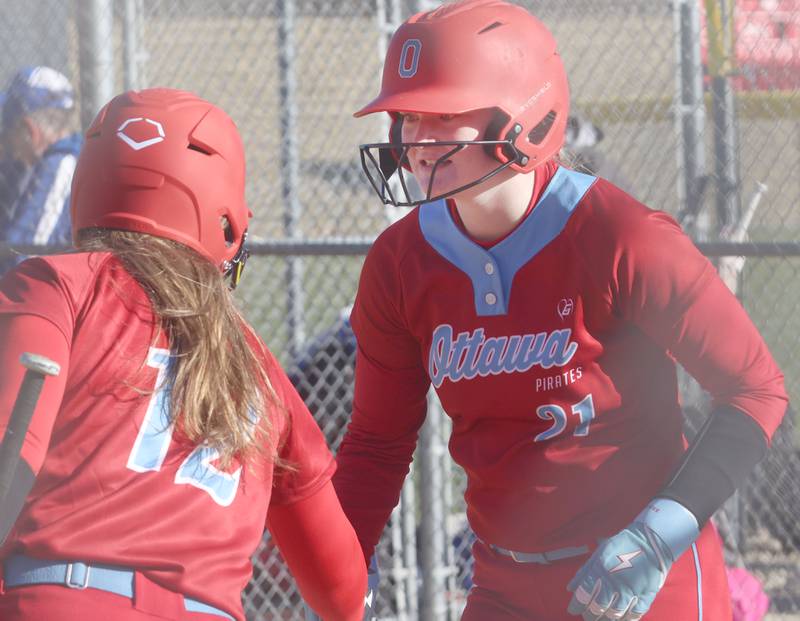 Ottawa's Piper Lewis smiles after scoring a run while hi-fiving teammate Kennedy Kane on Friday, March 13, 2026 at Ottawa High School.
