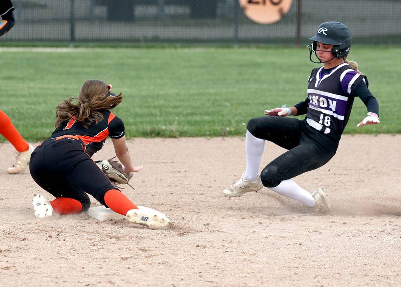 Dixon’s Bailey Tegeler slides in with a stolen base as the ball gets by DeKalb's Hazel Montavon Thursday, May 22, 2025, during their game at DeKalb High School.