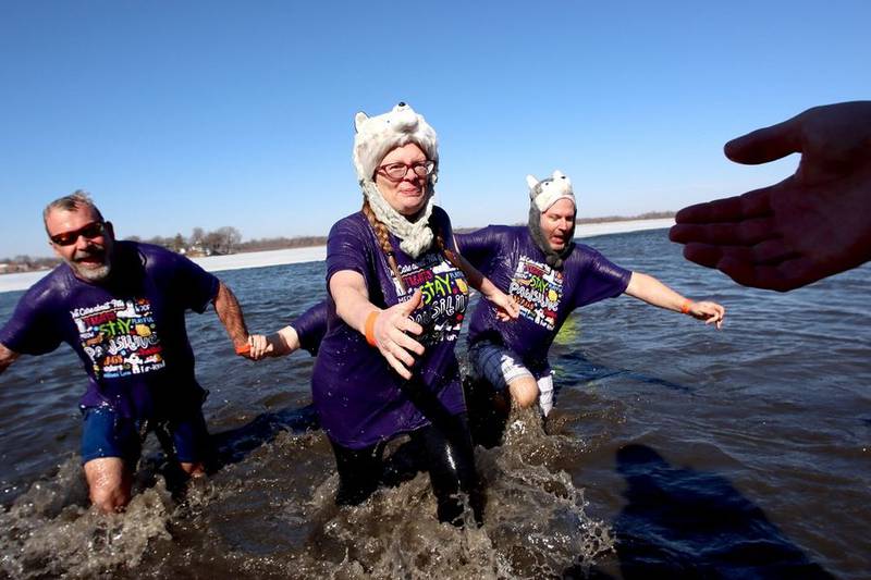 The team from Reese's Barkery and Pawtique exits the water Sunday, Feb. 20, 2022, during the Polar Plunge in Fox Lake.