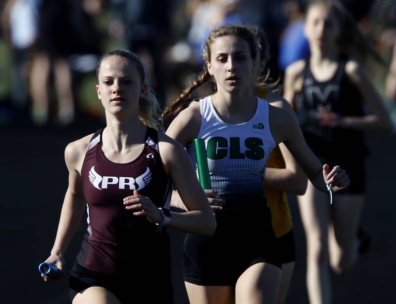 Prairie Ridge’s Rachel Soukup and Crystal Lake South’s Addie Frisch lead the first leg of the 4X800 relay Thursday, April 21, 2022, during the McHenry County Track and Field Meet at Richmond-Burton High School.