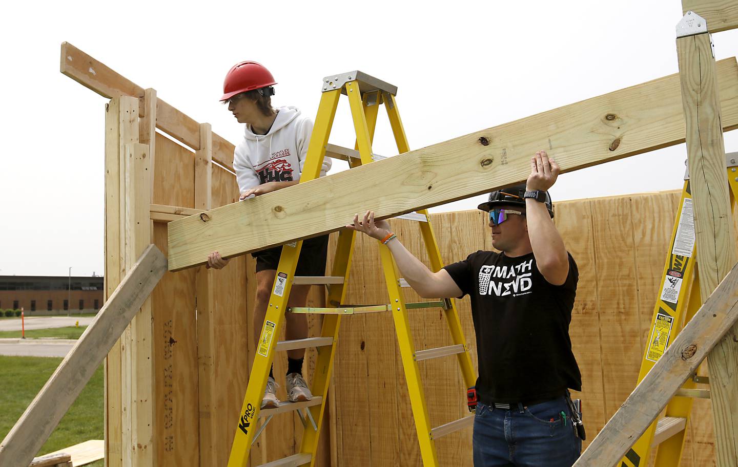 Huntley student Tyler Hofmann and math teacher James Allen lift a beam into place Thursday, May 18, 2023 as they build athletic field bench shelter at Huntley High School during the geometry in construction class at school. Huntley Community School District 158 has been recognized as a 2023 Spring “Lighthouse System” by AASA, The School Superintendents Association, to serve as a model of positive change in public education. It is one of six school districts from across the country to receive the award.