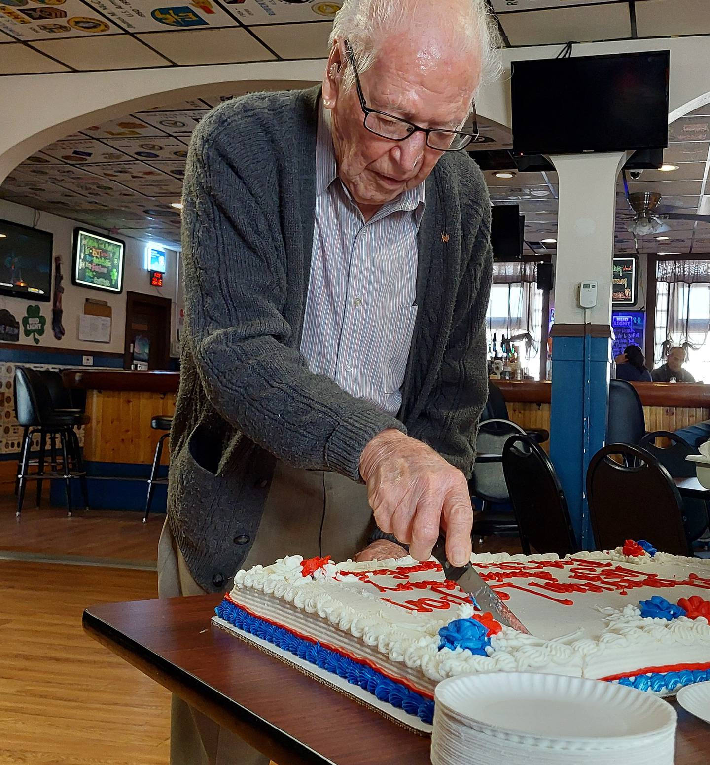 World War II veteran Francis “Kay” Killelea, 103, of Ottawa, cuts the cake celebrating the 105th anniversary of the Ottawa American Legion on Saturday, March 16, 2024.