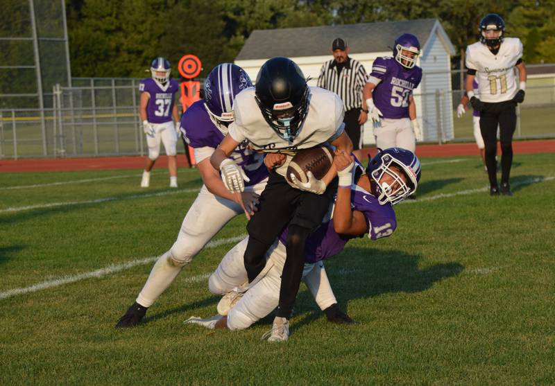 Rochelle's Kristian Dassie (13) and Jace Spears (23) tackle a Sycamore ballcarrier during their JV football game. Rochelle won the game 18-6.