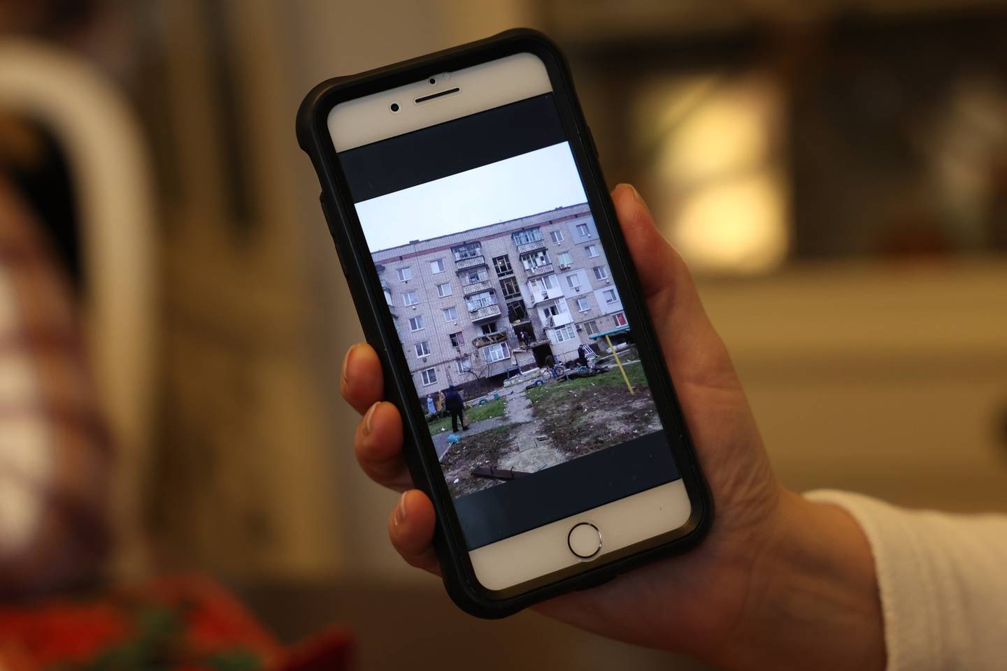 Iryna Baker, who left Ukraine in 2008, shows a Facebook Group photo of her old apartment building, now destroyed, in Oleshky, Ukraine.