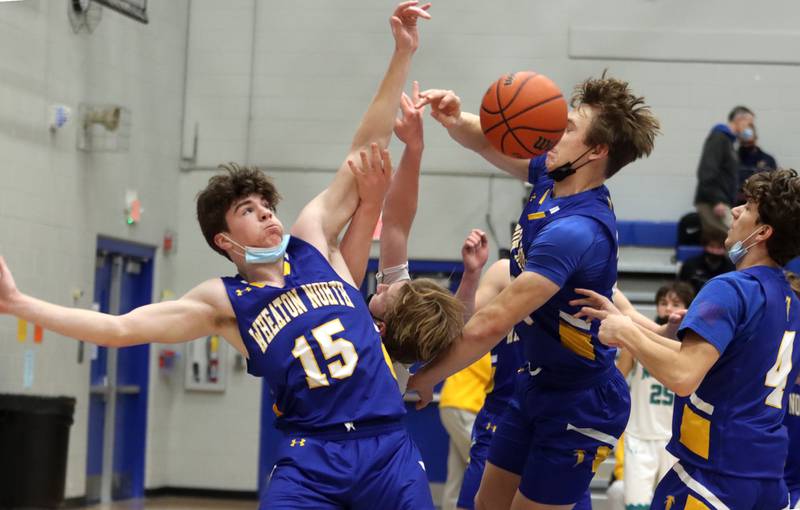Woodstock North’s Rex White is pressured by Wheaton North’s Eamon Kane, left, and Seth Kortenhoeven, right, under the hoop during MLK Tournament action at Burlington Central High School Saturday morning.