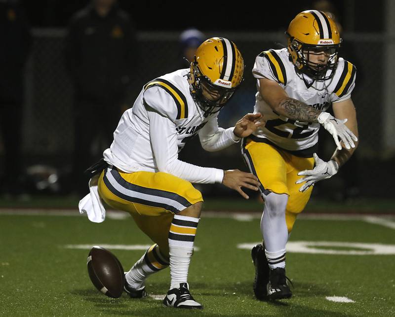 St. Laurence's Chase Kwiatkowski (left) looks for the football after fumbling the snap during an IHSA Class 4A first-round football game against Richmond-Burton on Friday, Nov. 1, 2024, at Richmond-Burton High School in Richmond.