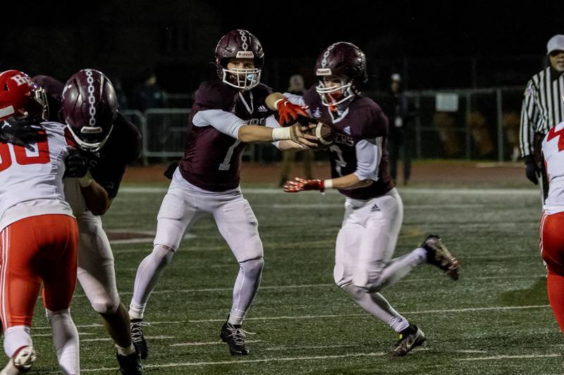 Lockport's Brendan Mecher hands-off to Lockport's Adam Kozak during an 8A varsity football playoff game against Homewood-Flossmoor at Lockport Township High School East Campus on Nov. 8, 2025.