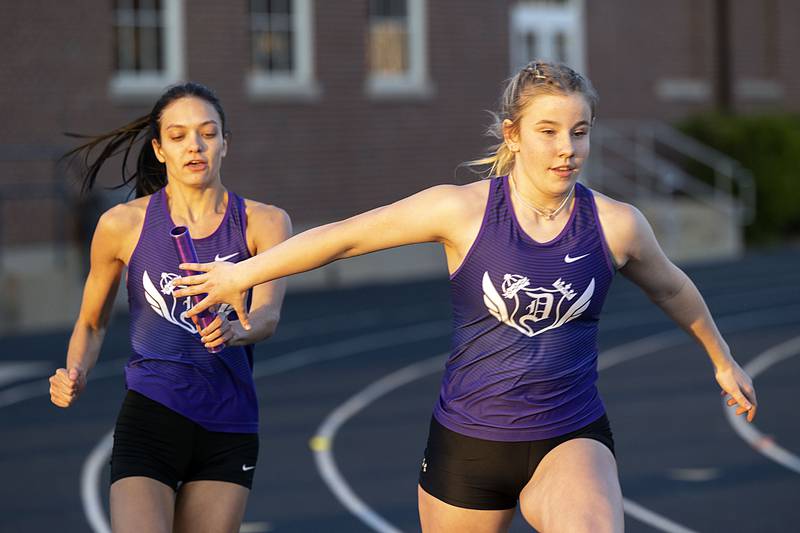 Dixon’s Skylar Smith reaches for the baton from Isabella Miller in the 4x100 Thursday, April 27, 2023 at the Sterling Night Relays..