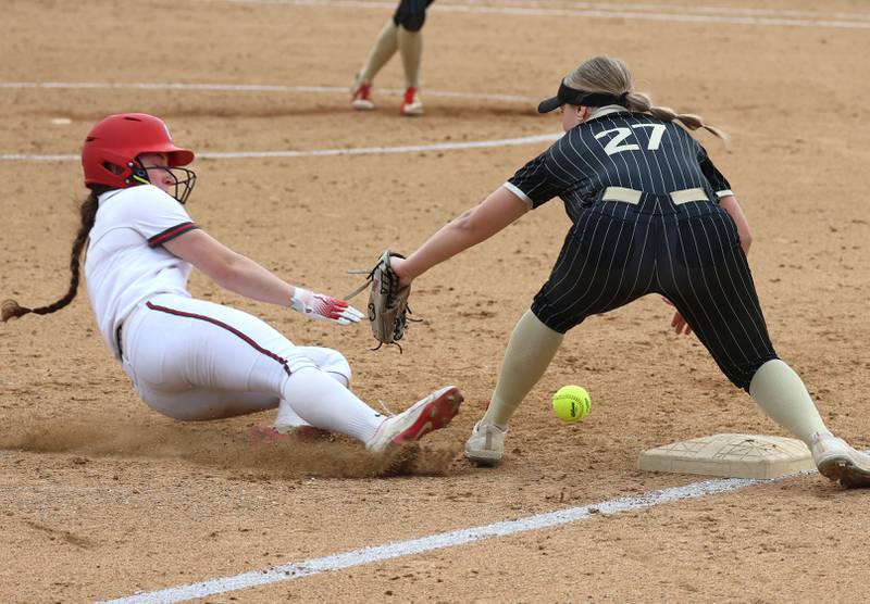 Ottawa's Avery Leigh slides in safely at third base as Sycamore's Addison Armstrong takes the throw Friday, April 17, 2026, during thier game at Sycamore High School.