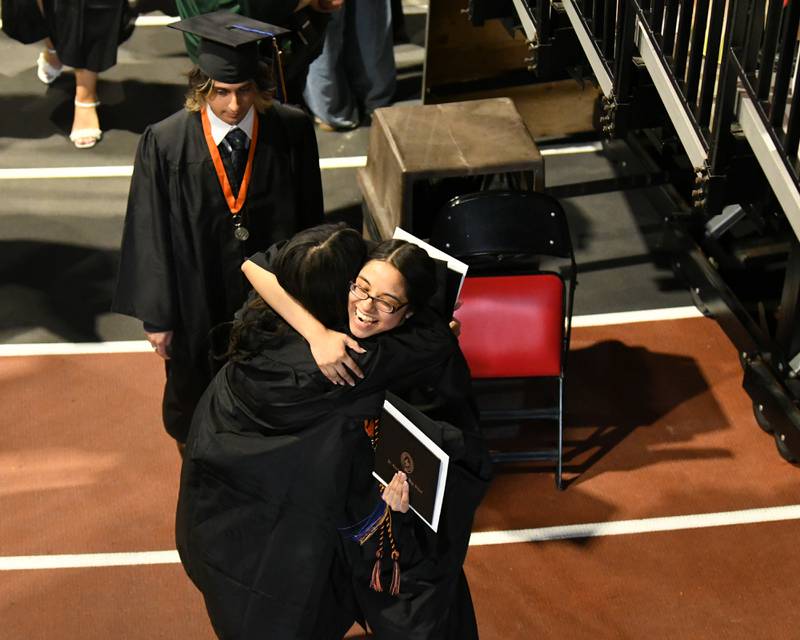 St. Charles East graduates hug each other before exiting the Convocation Center on Monday, May 18, 2026, marking the completion of the graduation ceremony.