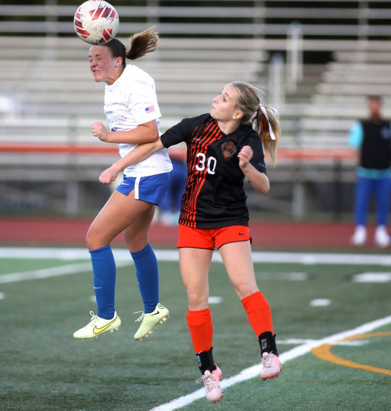 St. Charles North’s Keira Kelly heads the ball away from St. Charles East's Lilli Margewich during a Tri-Cities Soccer Night game on Tuesday, April 29, 2025 in St. Charles.