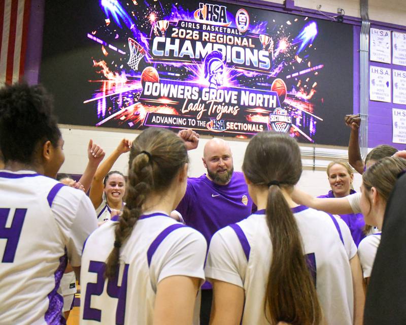 Downers Grove North's head coach Stephen Bolt celebrates with the team after winning the 4A regional championship game over St. Laurence on Thursday Feb. 19, 2026, held at Downers Grove North High School.