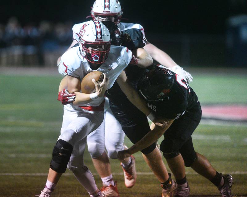 South Elgin quarterback John Ginnan (7) keeps the ball for a running play during Friday’s football game against Glenbard East in Lombard.