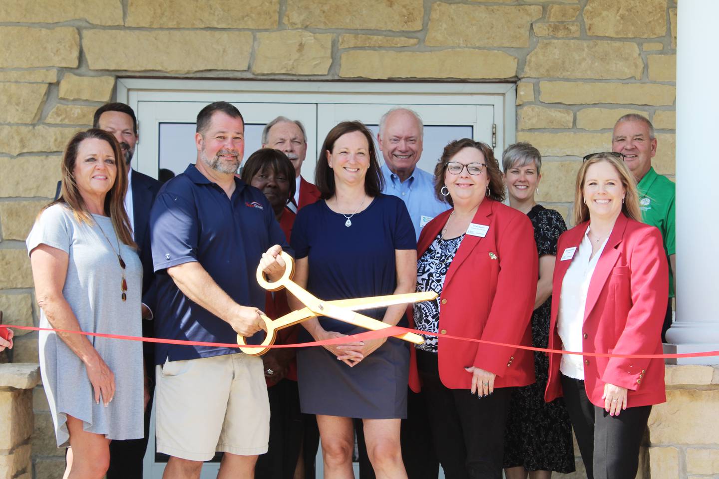 AutoSmart celebrated its grand opening on June 11, 2025 with a ribbon cutting, classic car show, flag raising ceremony, music from Lake Carroll DJ Ron Hennings, and food trucks from Copper Bee Coffee from Shannon and the Lanark VFW’s Mess Hall. Pictured with co-owners Brian (holding scissors) and Donna Caldwell are Freeport mayor Jodi Miller and members of the Freeport Chamber of Commerce and Greater Freeport Partnership.