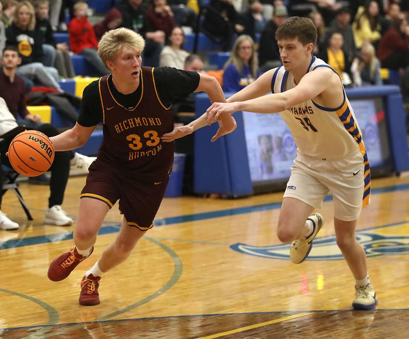 Richmond-Burton's Luke Robinson drives the baseline against Johnsburg's Danny Loud during the IHSA Class 2A Johnsburg Regional Championship boys basketball game on Friday, February, 27, 2026, at Johnsburg High School.