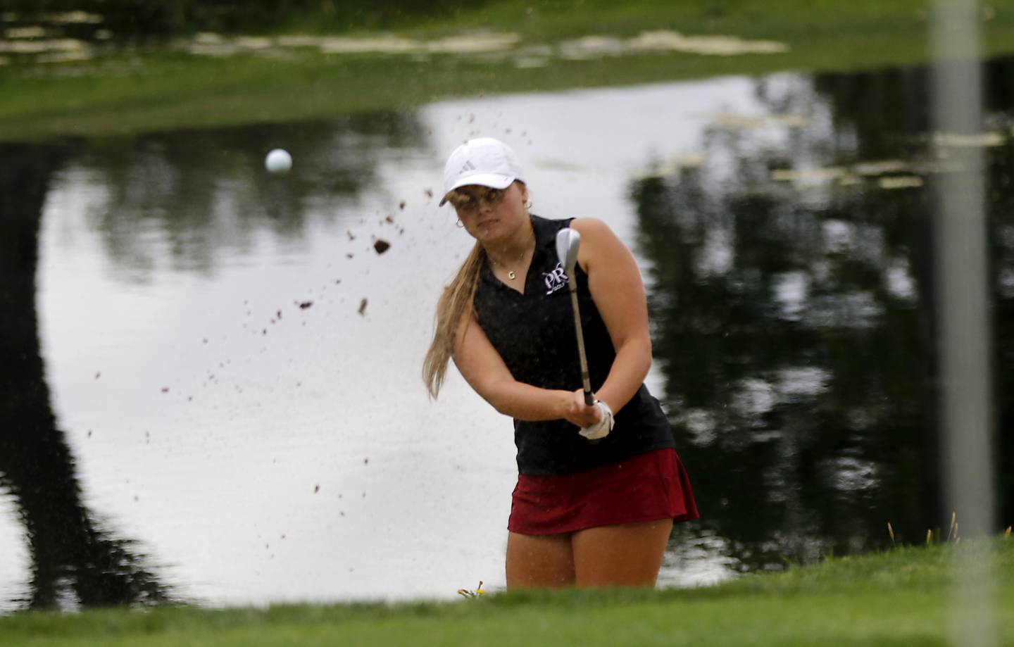 Prairie Ridge’s Grace Mertel chips out of the sand trap on the 12th green during the Fox Valley Conference Girls Golf Tournament Wednesday, Sept. 24, 2025, at Crystal Woods Golf Club in Woodstock.