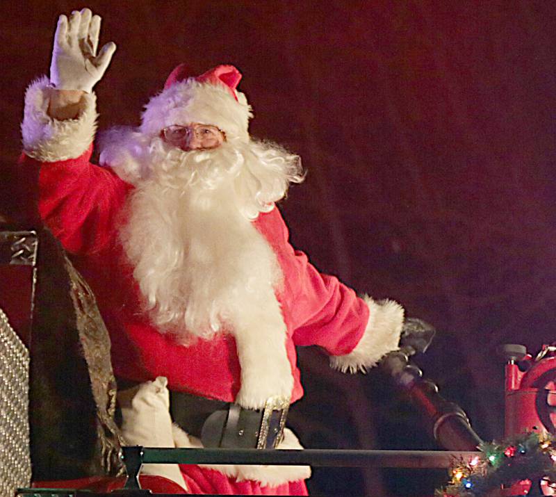 Santa waves to families on top of a Utica fire truck during the annual Santa parade throughout the village of Utica on Saturday. The Utica Fire Department has been having the Santa parade since 1941.