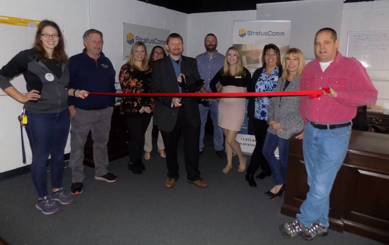 StratusComm Managed IT Founder & Managing Director, LeeJay Stewart is joined by members of his staff, Lais Titton, Marketing & Sales Specialist, and Ryan Malmstedt, IT Professional, and the staff and board members of the Cary-Grove Area Chamber of Commerce, to celebrate the Grand Opening of the new office location of StratusComm-Managed IT Services in Cary with a Ribbon Cutting ceremony.