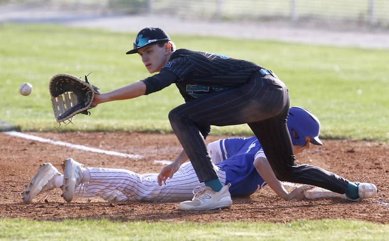Woodstock’s Trevor Cote dives back to first base in front of the throw to Woodstock North’s Cade Blaksley during a Kishwaukee River Conference baseball game Tuesday, April 18, 2023, at Emricson Park.