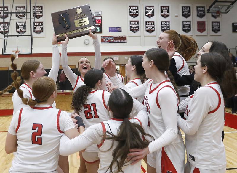 Huntley's Anna Campanelli raises the trophy and her teammates celebrate around her after Huntley defeated Libertyville  to win the  IHSA Class 4A Huntley Sectional Championship girls basketball game on Thursday, Feb. 27, 2025, at Huntley High School.