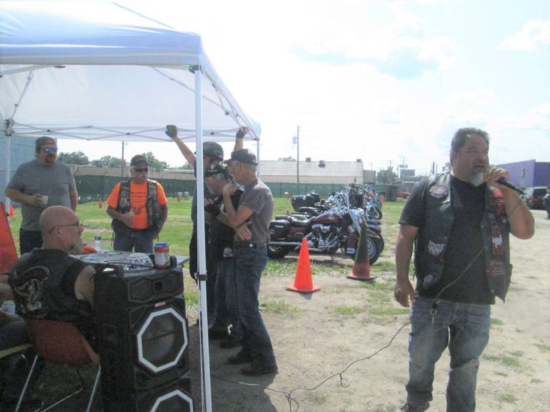 Open Roads ABATE member Ralph Torres, right, announces games during the Low Lyfz Motorcycle Club's Bike Rodeo while members Sam Mataya, Brian Smith, Cliff Oleson, and Doug Clevenger wait to assist.