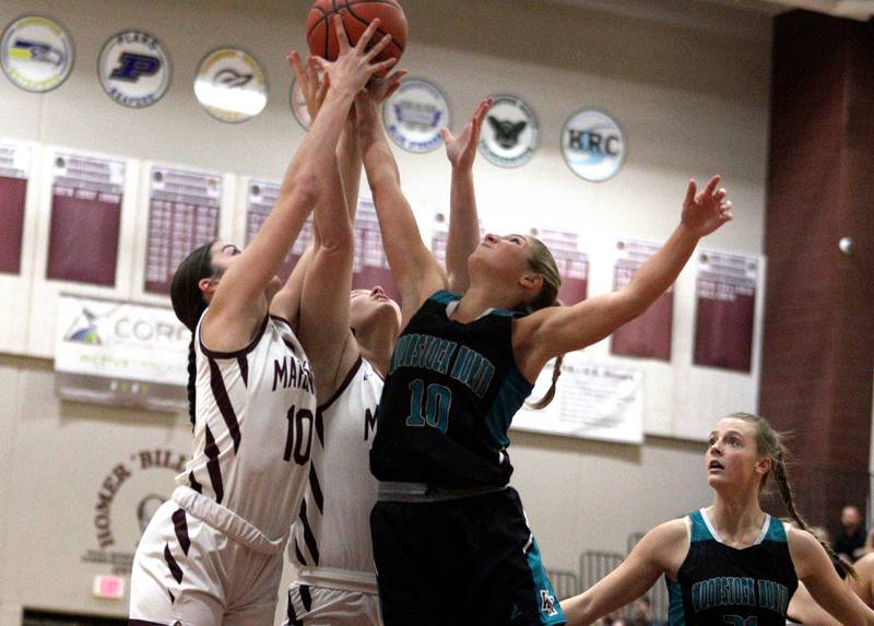 Marengo’s Bella Frohling, left, and Madison Cannon, center, battle Woodstock North’s Addison Rishling, right, for a rebound in varsity girls basketball at Marengo Tuesday evening.
