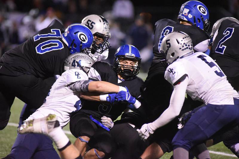 Geneva's Justin Taormina is taken down near the end zone by Oswego East's Jack Borvan (44) an Tahj Oliver (5) in the second quarter of playoff game Friday.