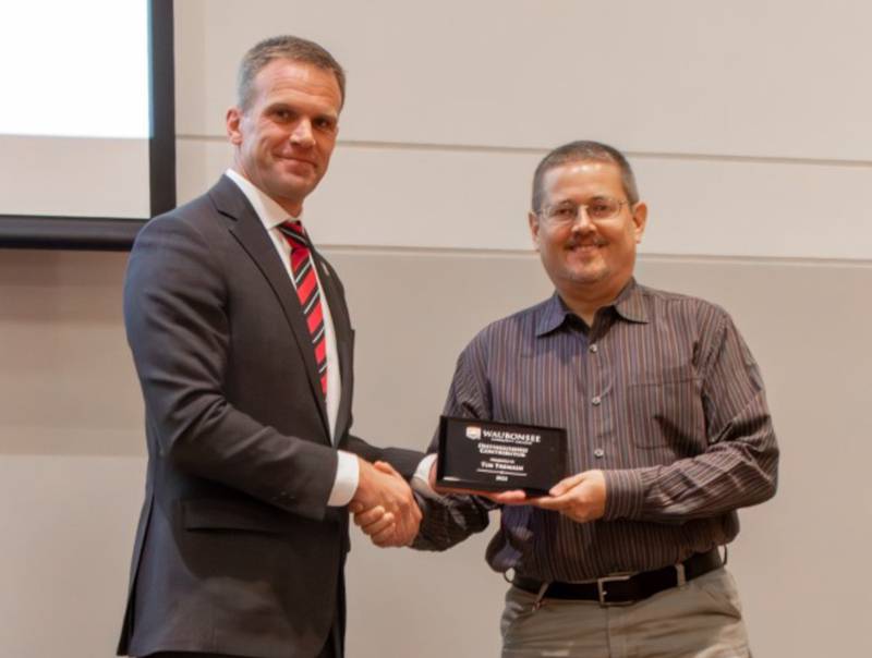 Dr. Brian Knetl, president of Waubonsee Community College, left, presents the 2023 Outstanding Contributor Award to Tim Tremain, president of MTH Pumps.