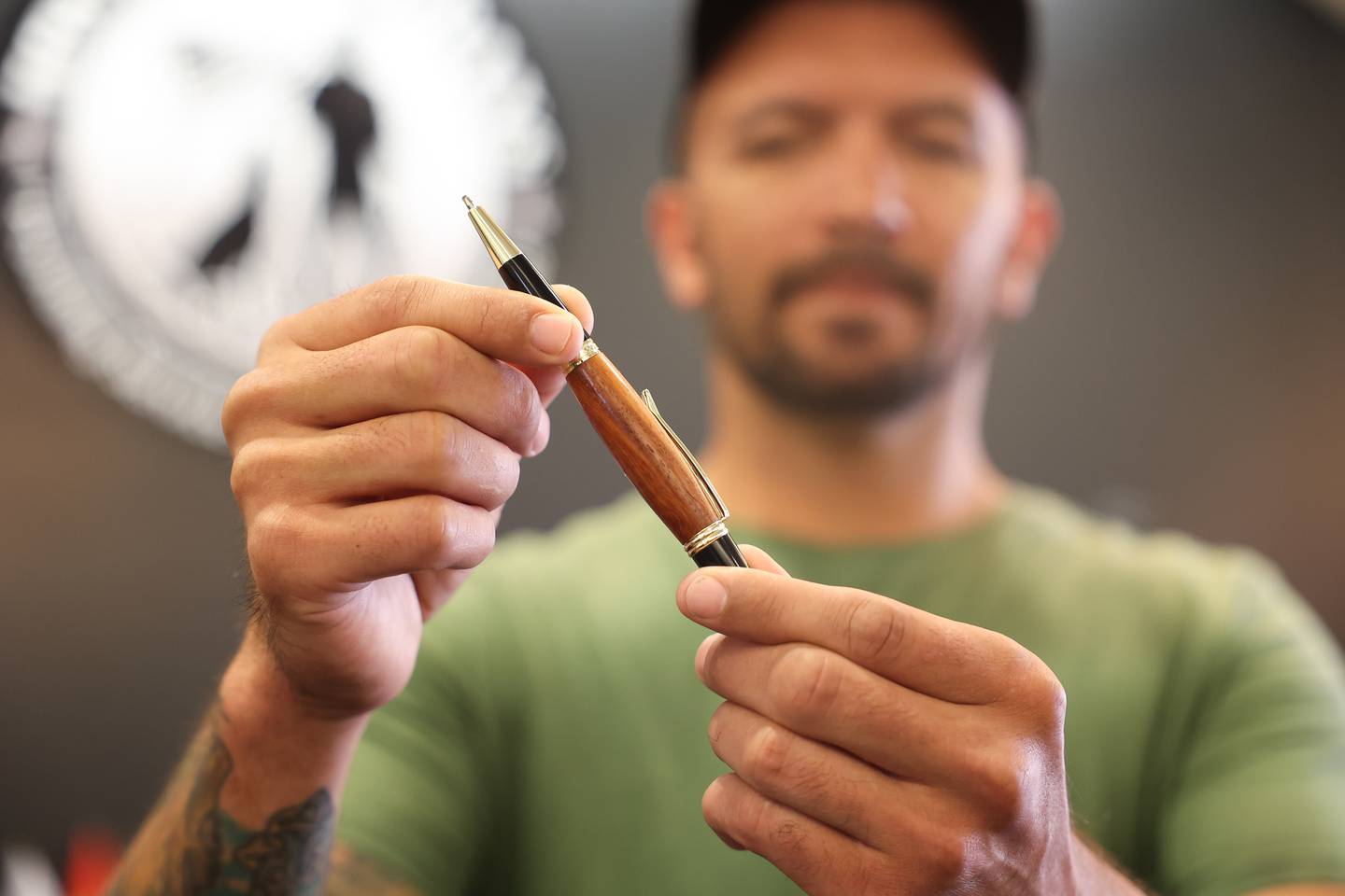 Samson Garcia, a disabled Army veteran, owner of Samson Wood Services, shows off one of his custom made pens  at K9s For Veterans Outlet Store where he sells some of his work in Bolingbrook, Thursday, July 25, 2024.