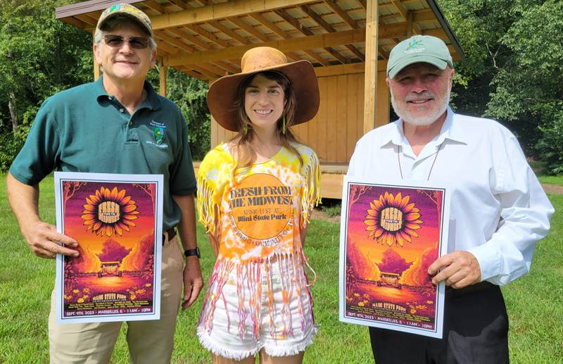 Organizers of the Fresh from the Midwest music festival (from left) Tom Jackson, Christina Eltrevoog and David Raikes, display posters for the event slated for 11 a.m.-10 p.m. on Sept. 9 at Illini State Park.