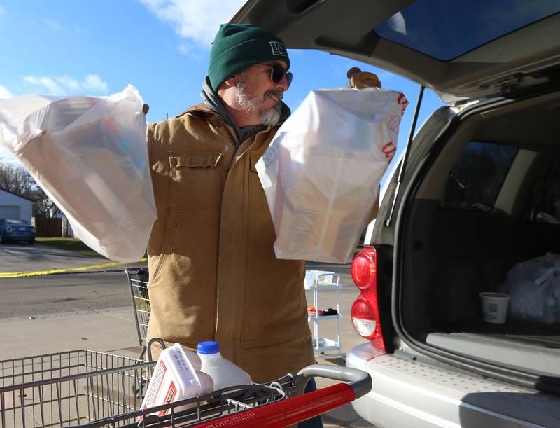 Jim Pienta volunteer at the Hall Township Food Pantry fills a clients car with food on Wednesday, Nov. 30, 2022 in Spring Valley.