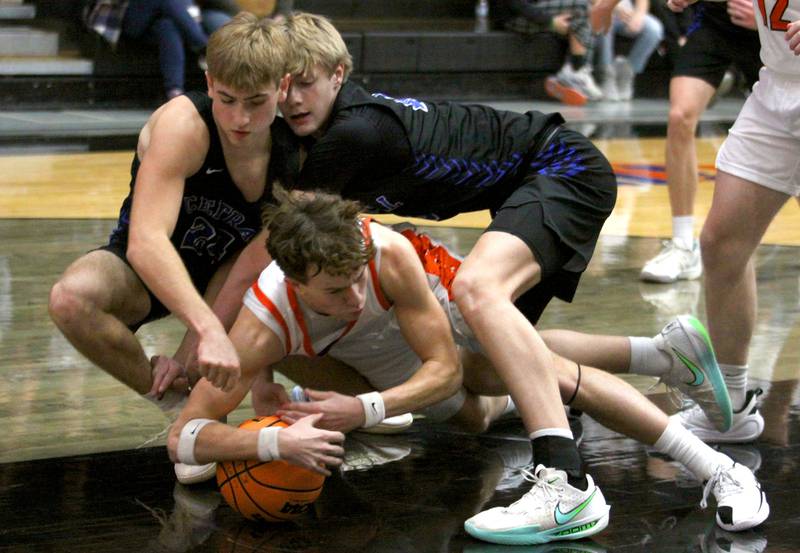McHenry’s Dayton Warren, bottom, tussles with Burlington Central’s Bennek Braden, left, and Declan Wilson for the ball in varsity boys basketball on Friday, Dec. 5, 2025, at McHenry Community High School in McHenry.