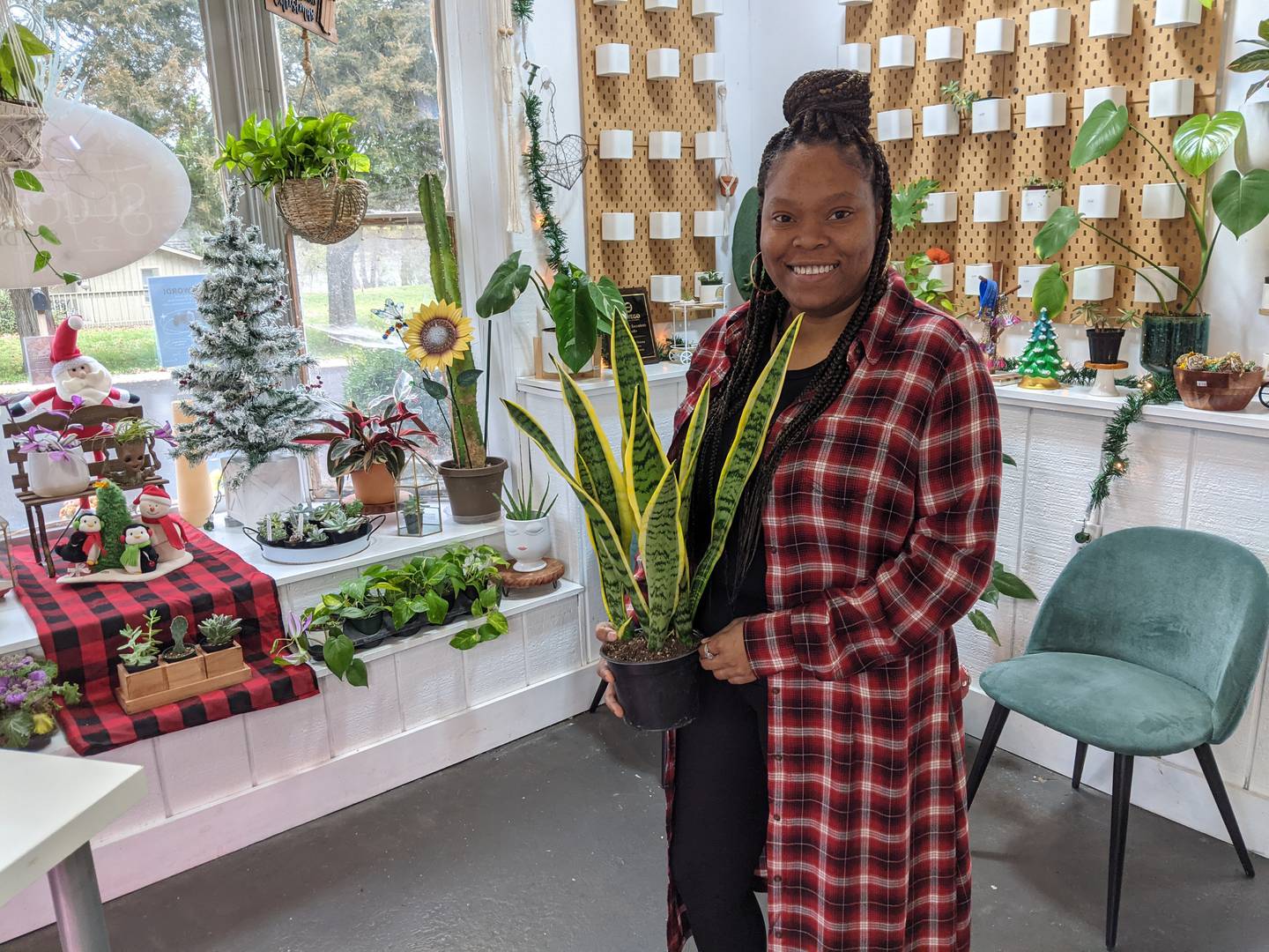 Blooming Succulents Studio founder Markita Young holds a snake plant.