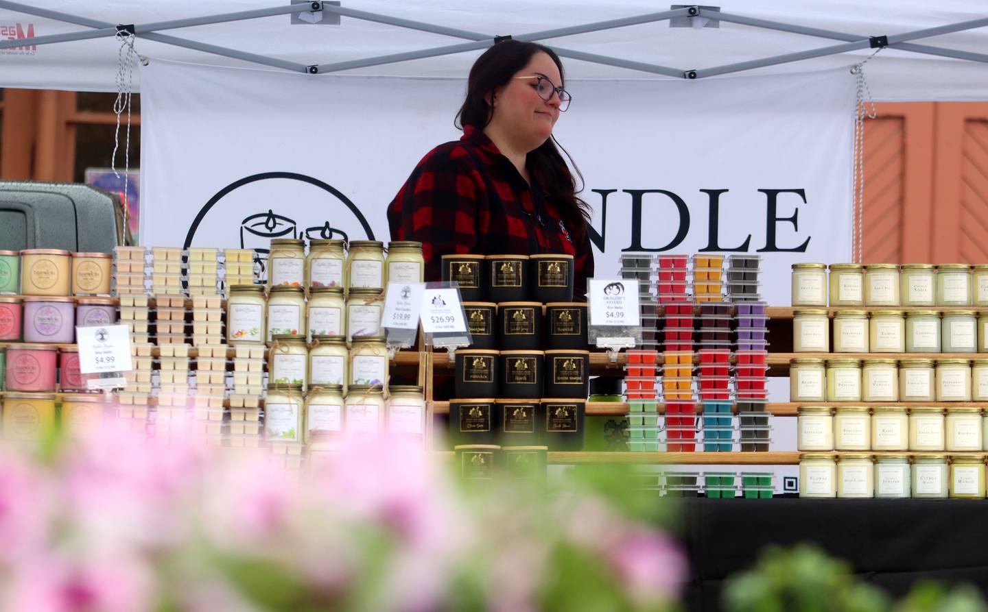Taylor Tatge minds the Candle Cubby booth during the farmers market Saturday, April 29, 2023, on the historic Woodstock Square.