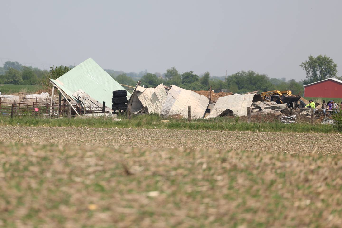 A collapsed structure can be seen from the road after a fire at a horse ranch Wednesday, May 24, 2023, in Beecher.