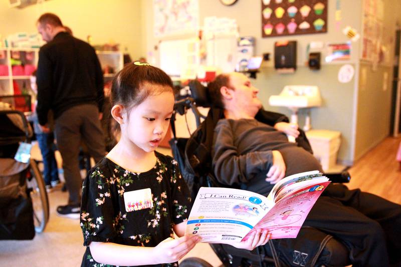 Grace McWayne Elementary School first grader Thea Tran reades to Marklund Hyde Center resident Shannon as the children also created Valentines with the residents on Wednesday, Feb. 7, 2024.